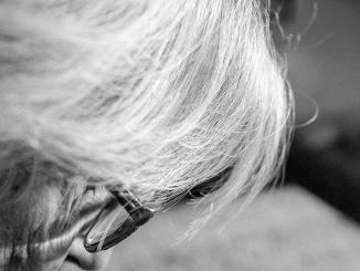 Alte Frau beugt sich über ein Buch. Foto: Natalia Overa.