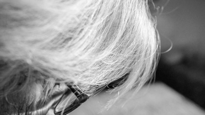 Alte Frau beugt sich über ein Buch. Foto: Natalia Overa.